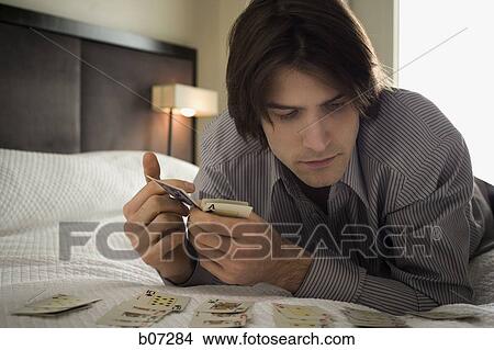 Man in hotel room playing solitaire View Large Photo Image Picture - Man in hotel room playing solitaire. Fotosearch