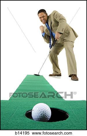 Stock Photography - Man in suit with putter and golf ball in hole. Fotosearch