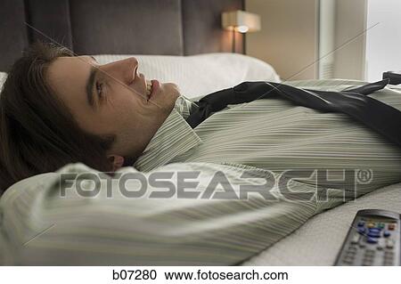 Stock Image - Man relaxing in hotel room. Fotosearch