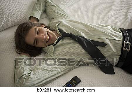 Stock Image - Man relaxing in hotel room. Fotosearch