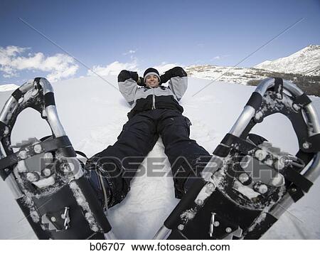 Stock Photo - Man resting with snow shoes. Fotosearch