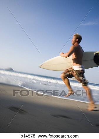 Man running on sandy beach with surfboard motion blur View Large Photo Image Stock Photo - Man running on sandy beach with surfboard motion blur. Fotosearch