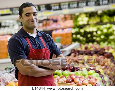 Man with apron in grocery store with arms crossed View Large Photo Image Picture - Man with apron in grocery store with arms crossed. Fotosearch