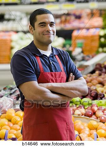 Man with apron in grocery store with arms crossed View Large Photo Image Stock Photograph - Man with apron in grocery store with arms crossed. Fotosearch