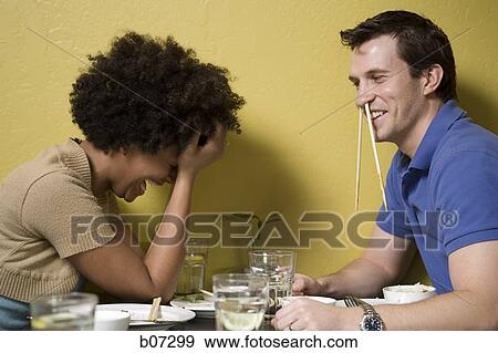 Stock Photo - Man with chopsticks in nose at restaurant. Fotosearch