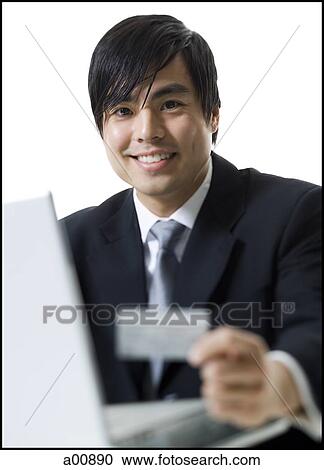 Stock Image - Man with credit card shopping online. Fotosearch