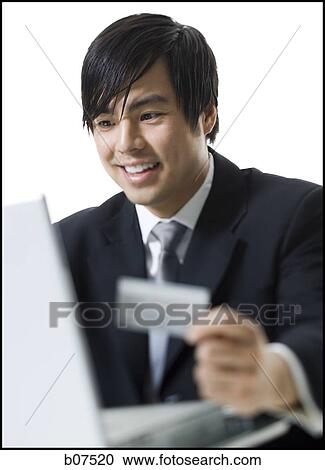 Stock Image - Man with credit card shopping online. Fotosearch