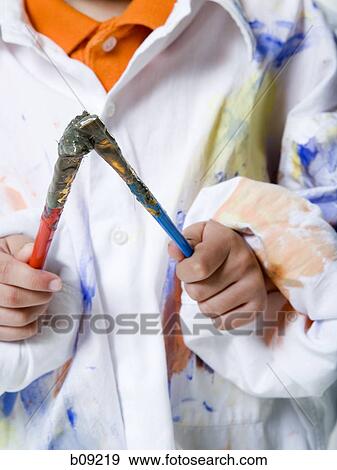 Mid section view of a boy holding a paintbrush View Large Photo Image Stock Photo - Mid section view of a boy holding a paintbrush. Fotosearch