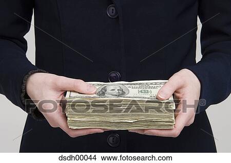 Mid section view of a businesswoman holding a bundle of dollars View Large Photo Image Picture - Mid section view of a businesswoman holding a bundle of dollars. Fotosearch