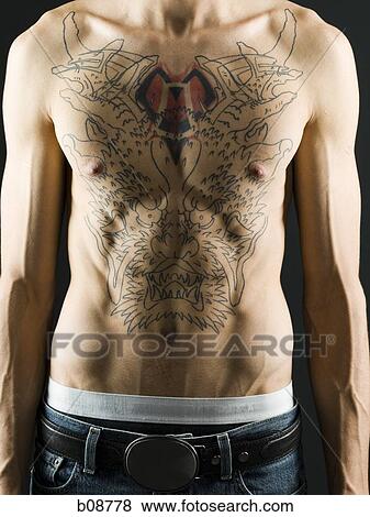 Mid section view of a young man with a tattoo on his chest View Large Photo Image Stock Photo - Mid section view of a young man with a tattoo on his chest. Fotosearch