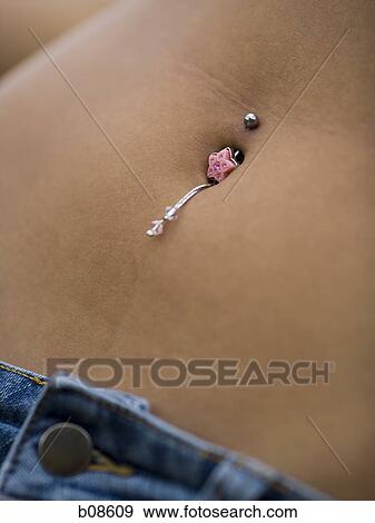 Mid section view of a young woman wearing a bellybutton ring View Large Photo Image Stock Photo - Mid section view of a young woman wearing a bellybutton ring. Fotosearch