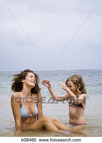 Mother and her daughter sitting in water View Large Photo Image Stock Photography - Mother and her daughter sitting in water. Fotosearch
