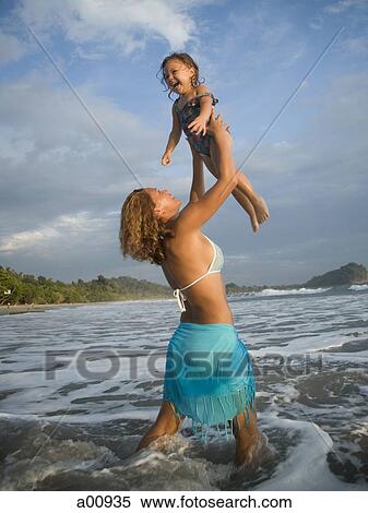 Mother playing with young daughter at beach View Large Photo Image Stock Photography - Mother playing with young daughter at beach. Fotosearch