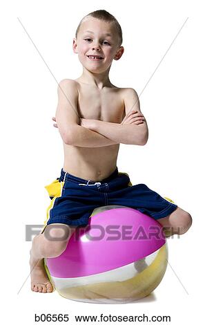 niño en una silla sentado y una pelota debajo niño en una silla sentado y una pelota debajo