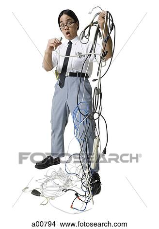 Office worker with tangled mess of wires View Large Photo Image Picture - Office worker with tangled mess of wires. Fotosearch