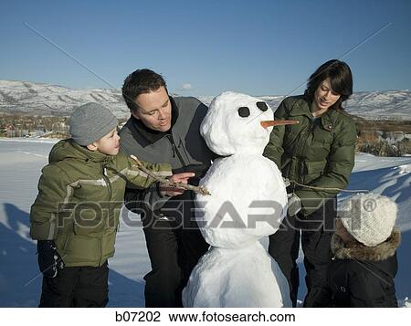 Parents and children making snowman View Large Photo Image Stock Image - Parents and children making snowman. Fotosearch