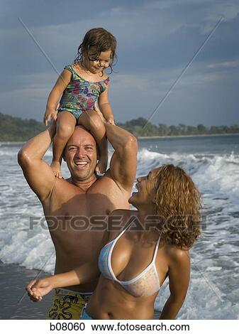Parents playing with young daughter on beach View Large Photo Image Stock Image - Parents playing with young daughter on beach. Fotosearch