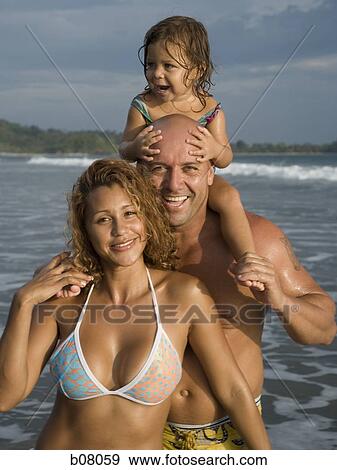 Parents playing with young daughter on beach View Large Photo Image Stock Photo - Parents playing with young daughter on beach. Fotosearch