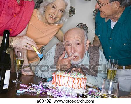 Partygoers around a birthday cake View Large Photo Image Stock Image - Partygoers around a birthday cake. Fotosearch