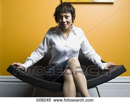 Portrait of a adult woman sitting on a chair and smiling View Large Photo Image Stock Photo - Portrait of a adult woman sitting on a chair and smiling. Fotosearch