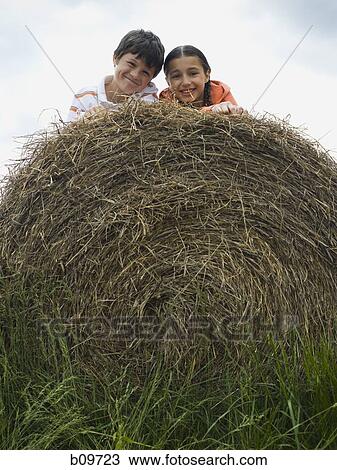 Portrait of a boy and a girl lying on top of a haystack View Large Photo Image Stock Image - Portrait of a boy and a girl lying on top of a haystack. Fotosearch