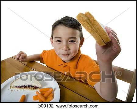 Stock Image - Portrait of a boy eating a sandwich. Fotosearch