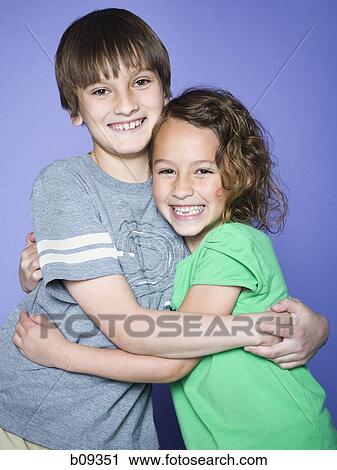 Portrait of a boy embracing his sister View Large Photo Image Stock Image - Portrait of a boy embracing his sister. Fotosearch