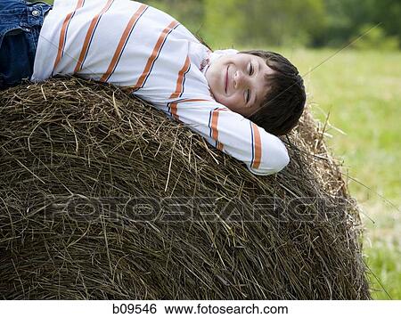 Portrait of a boy lying on a hay bale View Large Photo Image Stock Photograph - Portrait of a boy lying on a hay bale. Fotosearch