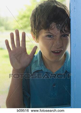 Portrait of a boy peeping through a window View Large Photo Image Stock Photograph - Portrait of a boy peeping through a window. Fotosearch