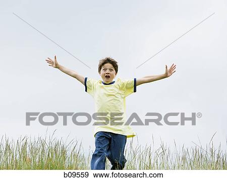 Portrait of a boy running with his arms outstretched View Large Photo Image Stock Photo - Portrait of a boy running with his arms outstretched. Fotosearch