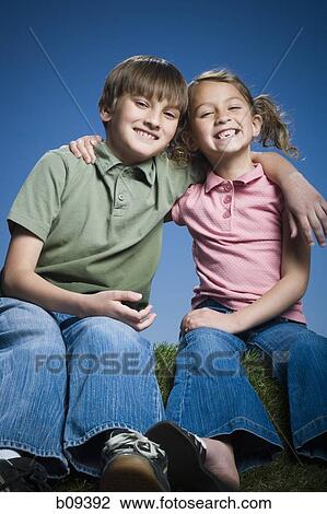Portrait of a boy sitting with his arm around his sister View Large Photo Image Stock Image - Portrait of a boy sitting with his arm around his sister. Fotosearch
