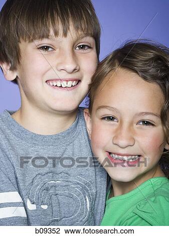 Portrait of a boy smiling with his sister View Large Photo Image Stock Image - Portrait of a boy smiling with his sister. Fotosearch
