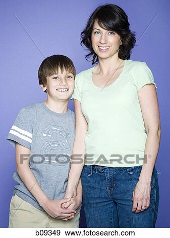 Portrait of a boy standing with his mother View Large Photo Image Stock Photo - Portrait of a boy standing with his mother. Fotosearch