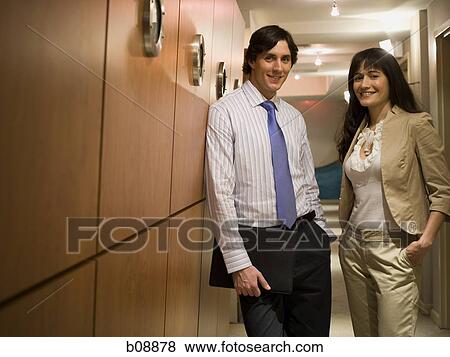 Portrait of a businessman and a businesswoman standing in a corridor View Large Photo Image Stock Photo - Portrait of a businessman and a businesswoman standing in a corridor. Fotosearch