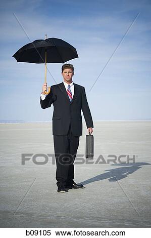 Portrait of a businessman holding an umbrella View Large Photo Image Stock Photography - Portrait of a businessman holding an umbrella. Fotosearch