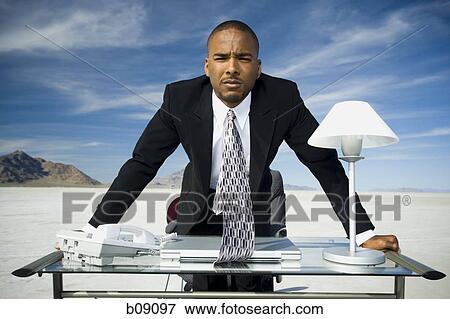 Portrait of a businessman leaning over a table View Large Photo Image Stock Photo - Portrait of a businessman leaning over a table. Fotosearch