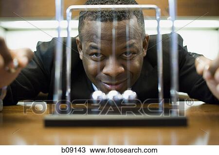 Portrait of a businessman looking at a pendulum and smiling View Large Photo Image Stock Image - Portrait of a businessman looking at a pendulum and smiling. Fotosearch