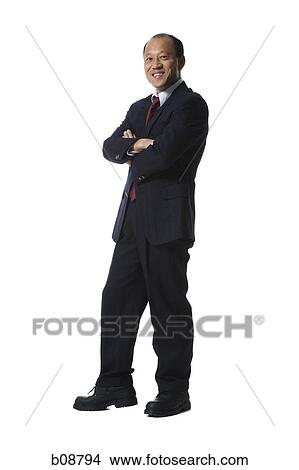 Picture - Portrait of a businessman standing with his arms folded and smiling. Fotosearch