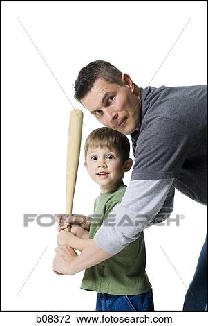 Stock Image - Portrait of a father teaching his son how to swing a baseball bat. Fotosearch