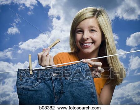 Portrait of a girl drying a pair of jeans on a clothesline View Large Photo Image Stock Image - Portrait of a girl drying a pair of jeans on a clothesline. Fotosearch