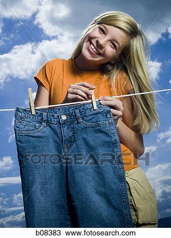 Portrait of a girl drying a pair of jeans on a clothesline View Large Photo Image Stock Image - Portrait of a girl drying a pair of jeans on a clothesline. Fotosearch