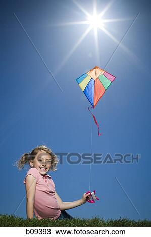Portrait of a girl flying a kite View Large Photo Image Stock Image - Portrait of a girl flying a kite. Fotosearch