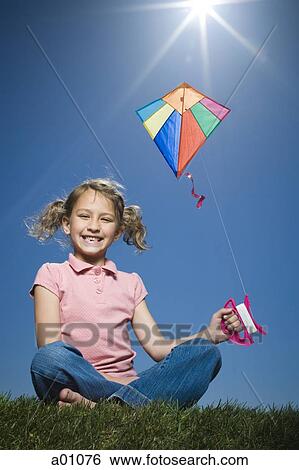 Portrait of a girl flying a kite View Large Photo Image Stock Photograph - Portrait of a girl flying a kite. Fotosearch