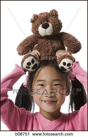 Portrait of a girl holding a teddy bear over her head and smiling View Large Photo Image Stock Image - Portrait of a girl holding a teddy bear over her head and smiling. Fotosearch