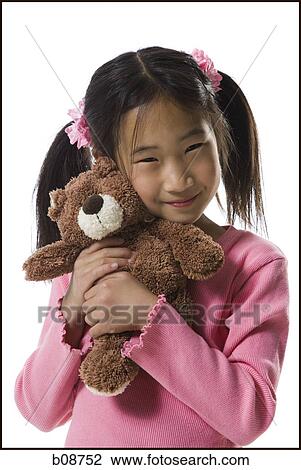 Portrait of a girl holding a teddy bear and smiling View Large Photo Image Stock Image - Portrait of a girl holding a teddy bear and smiling. Fotosearch