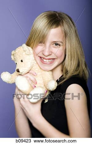 Portrait of a girl holding a teddy bear View Large Photo Image Stock Image - Portrait of a girl holding a teddy bear. Fotosearch
