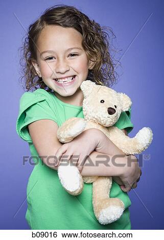 Portrait of a girl holding a teddy bear View Large Photo Image Stock Photograph - Portrait of a girl holding a teddy bear. Fotosearch