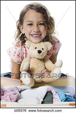 Portrait of a girl holding a teddy bear View Large Photo Image Stock Photograph - Portrait of a girl holding a teddy bear. Fotosearch