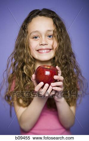 Portrait of a girl holding an apple View Large Photo Image Stock Photography - Portrait of a girl holding an apple. Fotosearch