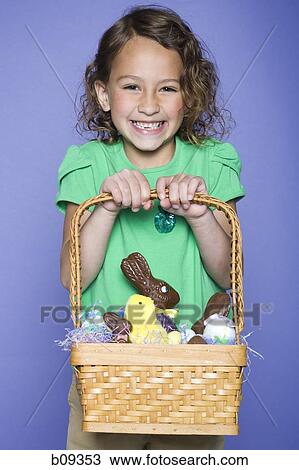 Portrait of a girl holding Easter bunnies and Easter eggs in a wicker basket View Large Photo Image Stock Image - Portrait of a girl holding Easter bunnies and Easter eggs in a wicker basket. Fotosearch